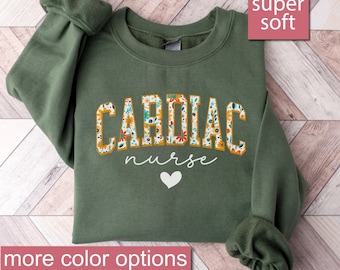 May include: A green sweatshirt with the text "CARDIAC NURSE" in floral print letters. The sweatshirt is super soft and has a heart design.