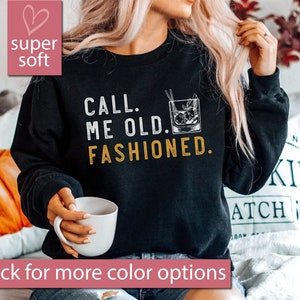 May include: Black sweatshirt with the text "CALL. ME OLD. FASHIONED." in white lettering and a drawing of an old fashioned cocktail glass in black and white.