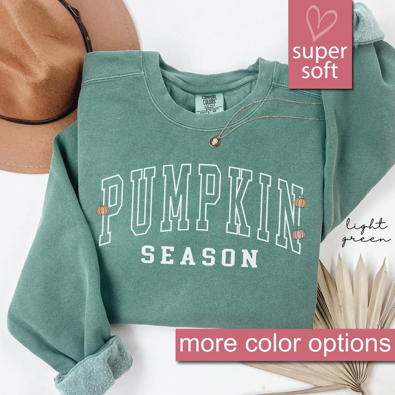 May include: Light green sweatshirt with the text "Pumpkin Season" in white. The sweatshirt has small pumpkin graphics on the front.