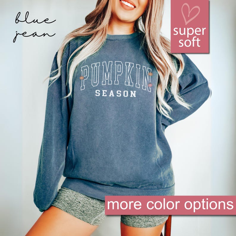 May include: A blue jean sweatshirt with the text "Pumpkin Season" in white lettering. The sweatshirt is super soft and has a relaxed fit.