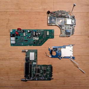 以下が含まれることがあります： 木製の表面に、緑色の基板が2枚、青色の基板が1枚、白黒のデザインの基板が1枚の計4枚の基板が並んでいます。