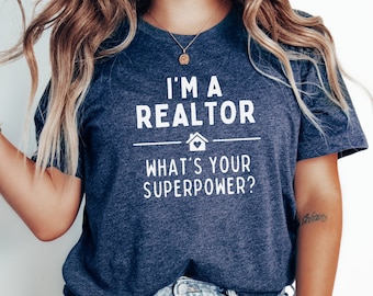 May include: A navy blue t-shirt with white text that reads "I'm a Realtor What's your superpower?" with a house icon and a heart.