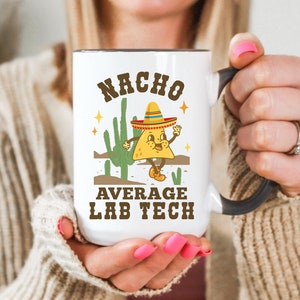 May include: White ceramic mug with a black handle. The mug has a cartoon image of a nacho wearing a sombrero and the text "Nacho Average Lab Tech".