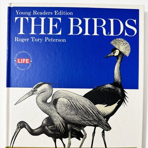 Op de afbeelding: Een boekomslag met een blauwe achtergrond en de titel "THE BIRDS" in witte tekst. Het boek maakt deel uit van de "Young Readers Edition" van de "LIFE Nature Library"-serie. De omslag toont een illustratie van drie vogels: een grijze reiger, een zwarte vogel met een lange snavel en een kraanvogel met zwart-wit verenkleed.