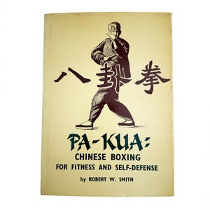 Pode incluir: Capa de livro vintage "PA-KUA: Chinese Boxing for Fitness and Self-Defense" de Robert W. Smith. A imagem apresenta uma ilustração em preto e branco de um artista marcial, com caracteres chineses acima.