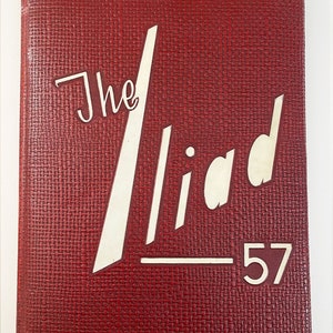 May include: A red hardcover book with the title "The Iliad" and the year "57" printed in white on the front cover.
