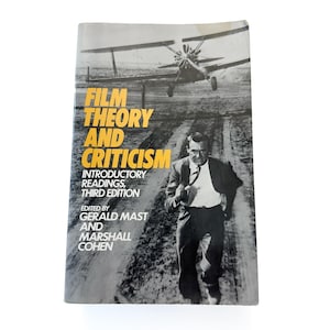 Puede incluir: Un libro antiguo titulado "Film Theory and Criticism" con una imagen en blanco y negro de un hombre caminando por un camino de tierra con un biplano al fondo. El título del libro está en amarillo y blanco.