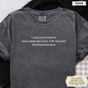 May include: A dark gray, long-sleeved t-shirt with the text "I analyze evidence (and sometimes your life choices) #forensicscience" in white. The shirt is soft-washed and garment-dyed.