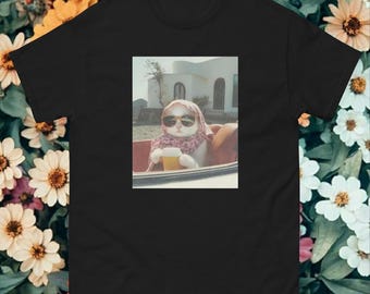 Puede incluir: Camiseta negra con una imagen de estilo vintage de un gato con gafas de sol y un pañuelo en la cabeza, sosteniendo una bebida. El gato está sentado en un coche, con un edificio al fondo. La imagen tiene una estética retro.