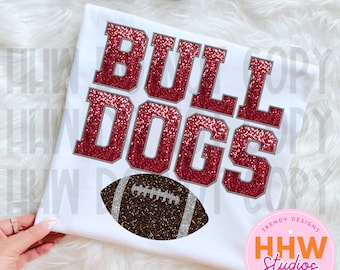 Peut inclure: T-shirt blanc avec le texte "BULLDOGS" en paillettes rouges et un graphique de ballon de football en paillettes brunes. Le texte est souligné en gris. Le t-shirt a un cercle rose avec le texte "TRENDY DESIGNS HHW Studios PNG & SVG FILES" en blanc.