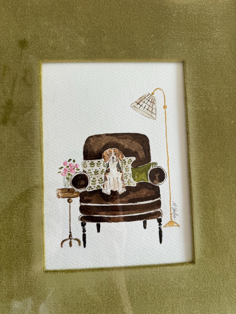 May include: A watercolor illustration featuring a brown and white beagle sitting on a dark brown armchair. The scene includes a small side table with pink flowers, a patterned throw pillow, and a tall floor lamp with a grid-patterned shade.