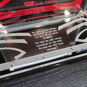 Puede incluir: Una imagen en blanco y negro de una cita del universo de Star Wars. La cita dice: "Por fin nos revelaremos a los Jedi. Por fin tendremos venganza."