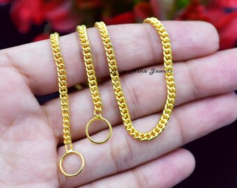 May include: Close-up of three gold-coloured curb chains with attached circular pendants. The chains are displayed against a blurred background, showcasing their shiny, reflective surface. The jewellery is likely for necklaces or bracelets.