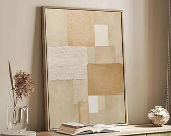 May include: An abstract framed artwork with beige and brown rectangular shapes hangs above a green cabinet. A clear vase with dried flowers, a decorative sphere, and an open book sit on the cabinet. A window with white shutters and a woven ottoman are also visible.