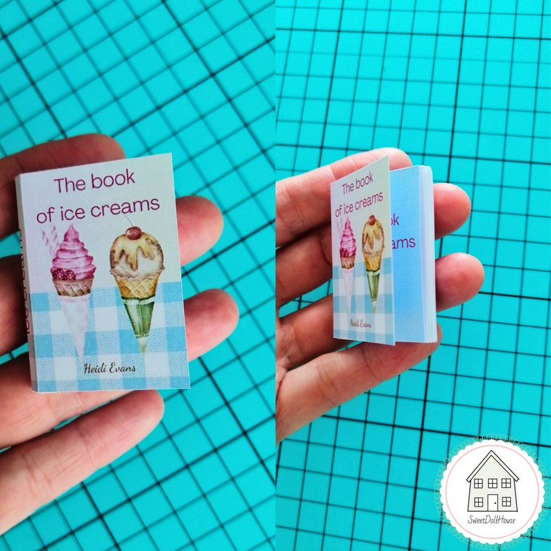 May include: A miniature book titled "The book of ice creams" with a blue and white checkered background and illustrations of two ice cream cones. The book is held in a hand.