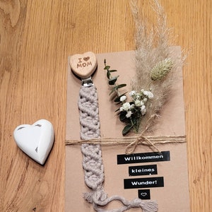 Handgefertigte Makramee Schnullerkette auf einer Karte mit Trockenblumen | Geschenk | handgemacht | Kraftpapier