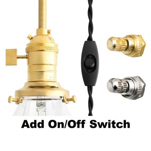 May include: A gold-toned light fixture with a clear glass shade and a black on/off switch. The switch is attached to a black braided cord.