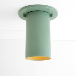 May include: A green cylindrical ceiling light fitting with a round base.