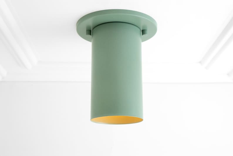 May include: A green cylindrical ceiling light fitting with a round base.