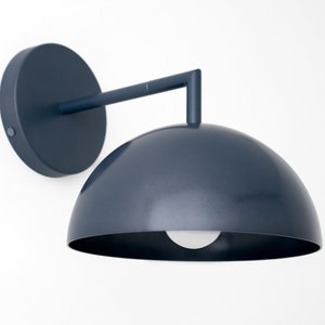 Puede incluir: Una l&aacute;mpara de pared de color azul oscuro con una pantalla en forma de c&uacute;pula. La l&aacute;mpara tiene un dise&ntilde;o simple y moderno y es perfecta para a&ntilde;adir un toque de estilo a cualquier habitaci&oacute;n.