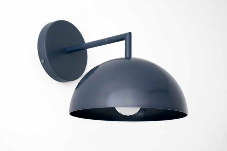 Puede incluir: Una l&aacute;mpara de pared de color azul oscuro con una pantalla en forma de c&uacute;pula. La l&aacute;mpara tiene un dise&ntilde;o simple y moderno y es perfecta para a&ntilde;adir un toque de estilo a cualquier habitaci&oacute;n.
