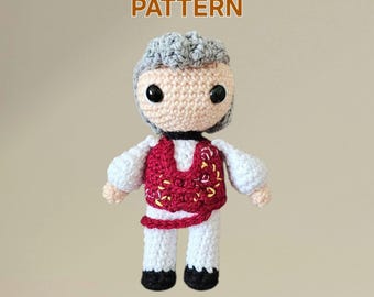 May include: Crocheted doll with a light skin tone, gray hair, and black eyes. The doll wears a red vest with yellow accents over a white shirt, white pants, and black shoes. The word "PATTERN" is at the top.
