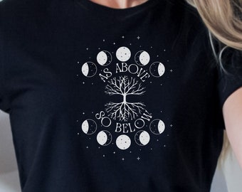 May include: Black t-shirt featuring a white graphic design. The design includes a tree with roots and branches, surrounded by phases of the moon and the text "AS ABOVE SO BELOW". The shirt has short sleeves and a crew neck.