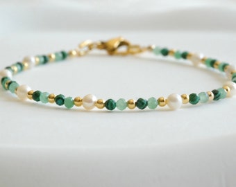 May include: Delicate bracelet featuring alternating white pearls, green beads, and gold-colored accents. The bracelet is strung on a fine chain and secured with a gold-colored clasp. A simple and elegant piece of jewelry.