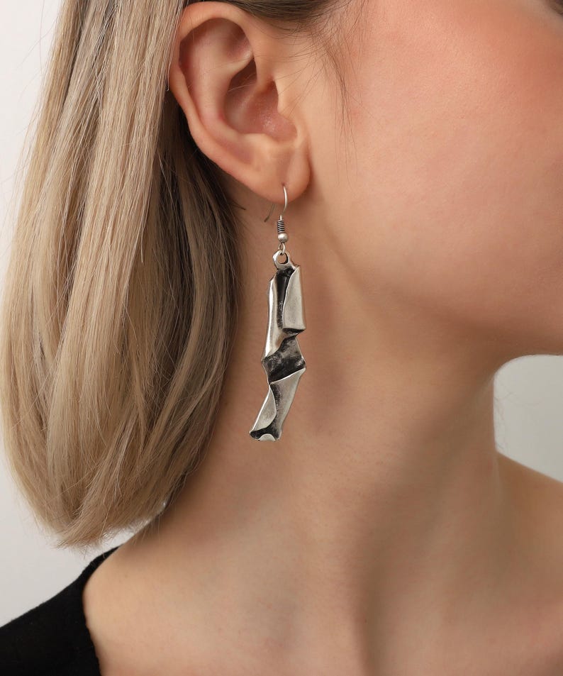 May include: Silver abstract shaped dangle earrings