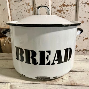 May include: White enamel bread bin with a black rim and black lettering that reads "BREAD".