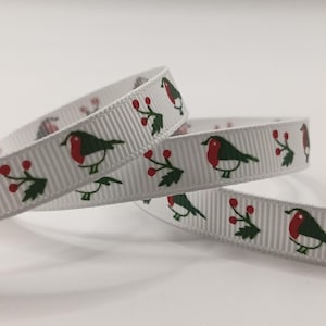 Pode incluir: Fita branca com um padrão repetido de rouxinóis e bagas vermelhas. Os rouxinóis têm peito vermelho e asas verdes. As bagas são vermelhas com folhas verdes. Ideal para artesanato ou embrulho de presentes.