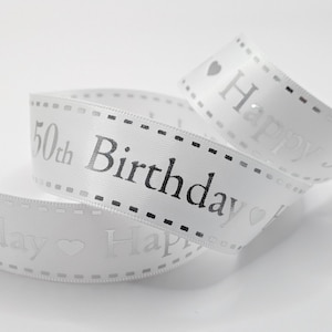 May include: White ribbon with silver text reading "50th Birthday" and "Happy". The ribbon features a dotted border and heart accents. Suitable for gift wrapping or party decorations.