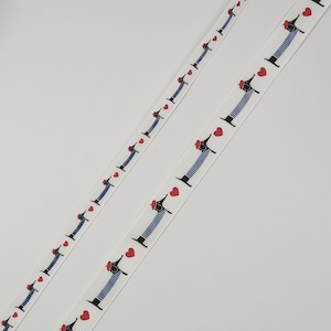 Peut inclure: Ruban blanc orné d'un motif répété de teckels portant des chemises rayées et des bérets rouges, chacun avec un cœur rouge. Les chiens ont des pattes noires et sont sur fond blanc.