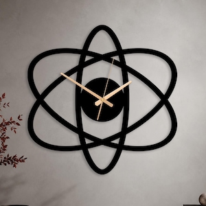 May include: A wall clock featuring a black atom-inspired frame with intersecting elliptical orbits. The center of the clock is a solid black circle with thin, metallic gold-colored hour, minute, and second hands extending outward.