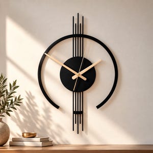 Può includere: Un orologio da parete con una cornice circolare nera e un disco centrale nero. Il design include linee verticali nere che si estendono sopra e sotto il centro. L'orologio ha tre lancette sottili di colore chiaro sul quadrante nero.