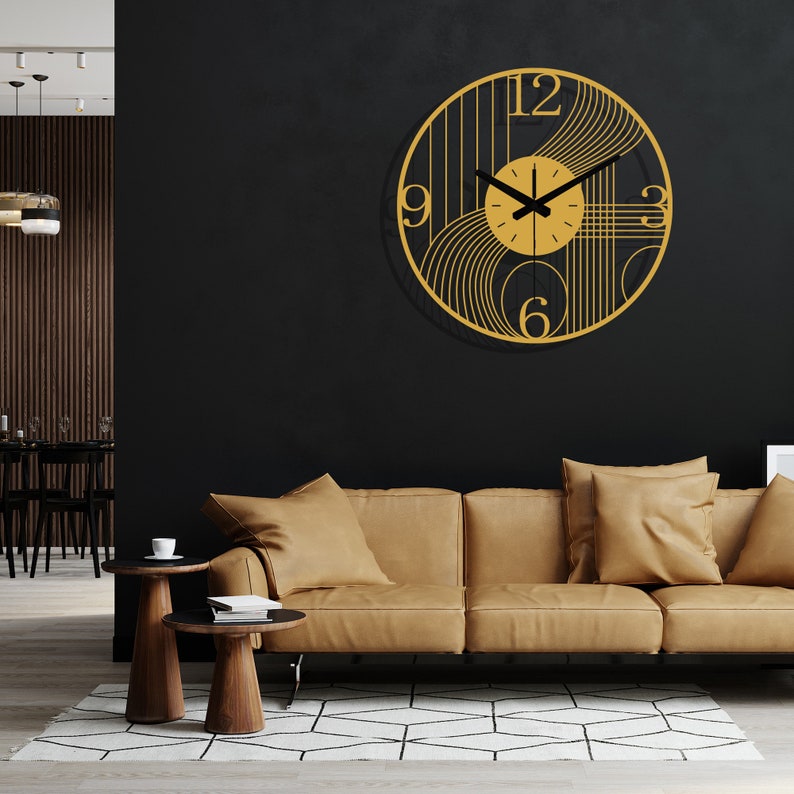 May include: A gold and black wall clock with a geometric design. The clock has black hands and Roman numerals. The clock is hanging on a black wall above a brown couch.