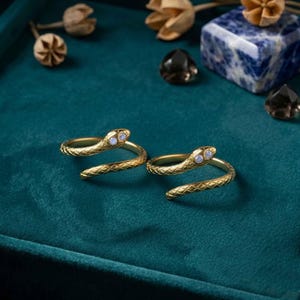 May include: A white ceramic mug with a black handle and the text "But First, Coffee" in a handwritten style. The mug is on a white surface. The mug is likely for hot beverages.