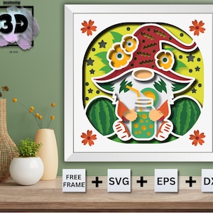 Puede incluir: Un diseño de papelcraft con un gnomo que lleva un sombrero rojo y blanco, sentado en una sandía y sosteniendo un vaso de jugo. El diseño está rodeado de hojas verdes y flores amarillas.