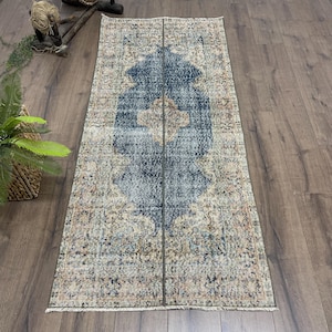 May include: A white ceramic mug with a black handle and the text "But First, Coffee" in a black, handwritten-style font. The mug is on a white surface.