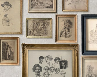 May include: A collection of framed black and white drawings and sketches on a light gray textured wall. The frames are in various sizes and styles, including gold, black, and wood. The drawings depict a variety of subjects, including people, buildings, and landscapes. The text "GREENHOUSE HOTEL ORIGINAL & VINTAGE DECOR" is printed below the frames.