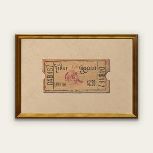 May include: A framed vintage rodeo ticket with a tan background and a gold frame. The ticket is tan with red text and a graphic of a rodeo rider. The ticket reads "First Rodeo" and "Admit One".
