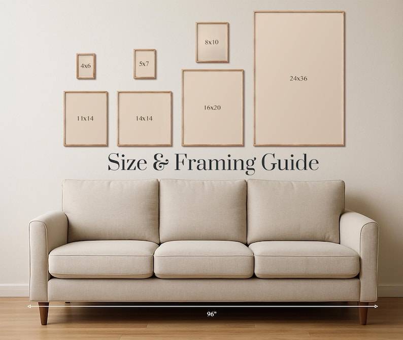 May include: A beige sofa with wooden legs is positioned below a wall displaying framed art prints of various sizes. The frames are a light wood color, and the wall has a neutral tone. The text "Size & Framing Guide" is displayed.