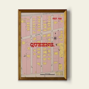 May include: A framed vintage map print of Queens, New York, with a gold-colored frame. The map features a pink background with yellow building outlines and red text that reads "QUEENS." The print also includes street names and a compass rose.