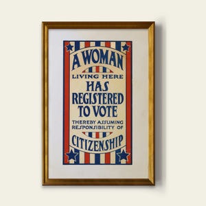 May include: Framed vintage poster with a gold-colored frame. The poster has a red, white, and blue color scheme with the text "A WOMAN LIVING HERE HAS REGISTERED TO VOTE THEREBY ASSUMING RESPONSIBILITY OF CITIZENSHIP". The poster features stars and stripes.