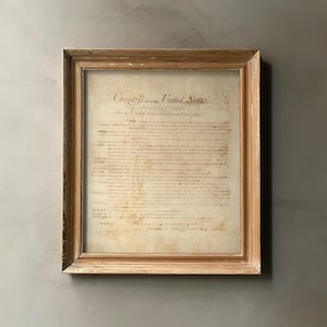 Może przedstawiać: Wydrukowana i oprawiona Deklaracja Niepodległości, historyczny dokument podpisany przez Ojców Założycieli Stanów Zjednoczonych. Dokument jest napisany kursywą i zawiera zdanie "Kongres Stanów Zjednoczonych".