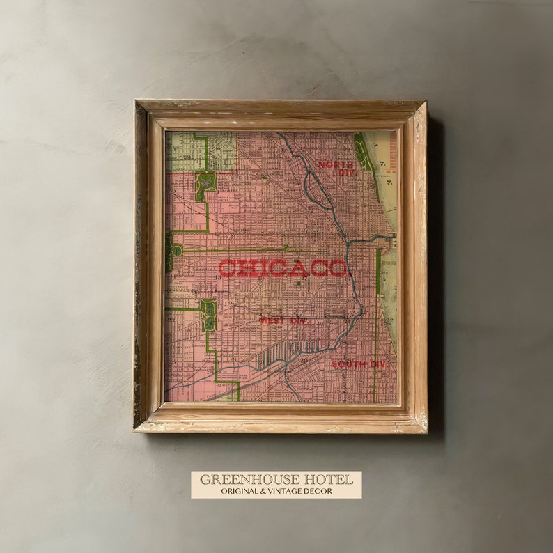 May include: Framed vintage map of Chicago in shades of pink and green, with the city name in bold red letters. The map is encased in a light brown wooden frame. The text "GREENHOUSE HOTEL ORIGINAL & VINTAGE DECOR" is at the bottom.