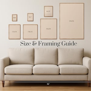 May include: A beige sofa with wooden legs is positioned below a wall displaying framed art prints of various sizes. The text "Size & Framing Guide" is displayed above the sofa. The sofa is 96 inches wide.