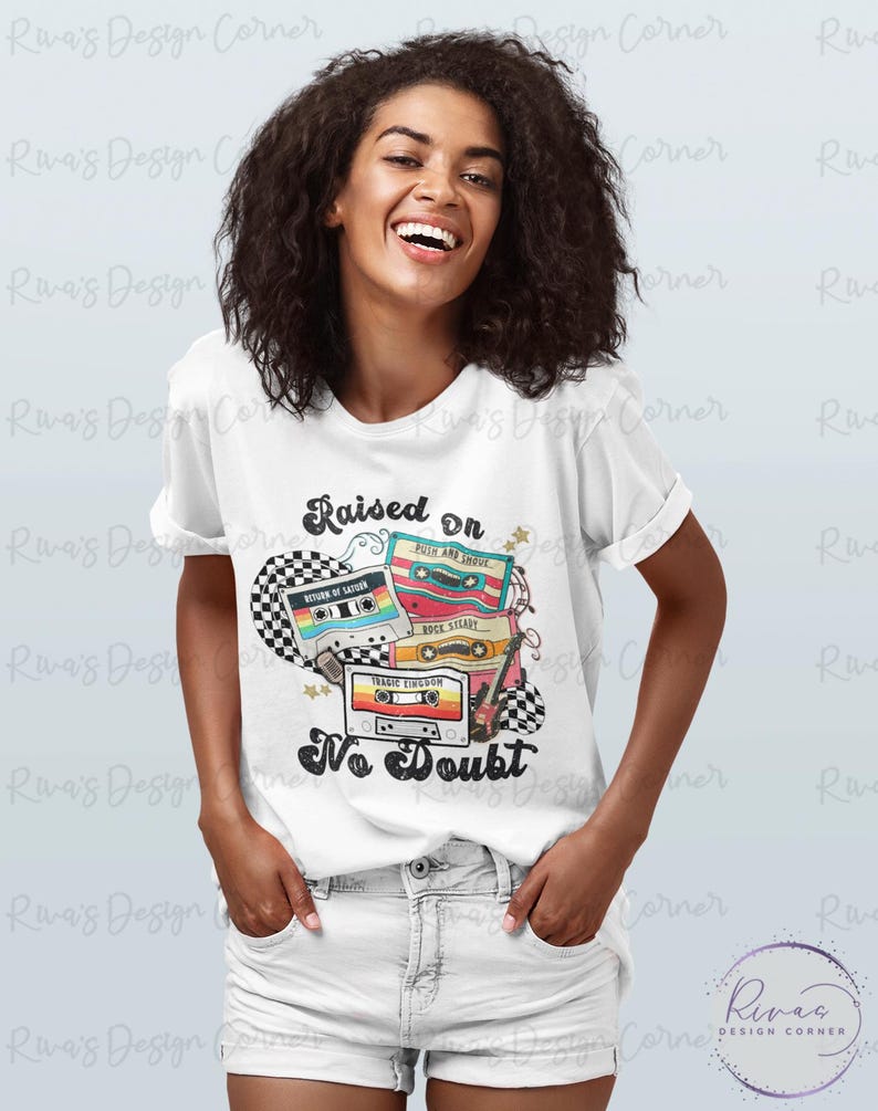 Puede incluir: Camiseta blanca con un dise&ntilde;o retro con cintas de cassette y el texto "Raised on No Doubt". El gr&aacute;fico incluye un patr&oacute;n de cuadros y estrellas. Un art&iacute;culo casual para el uso diario.