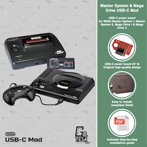Peut inclure: Consoles SEGA Master System II et Mega Drive noires avec une manette. L'image comprend une carte d'alimentation USB-C et le texte « Master System & Mega Drive USB-C Mod ».