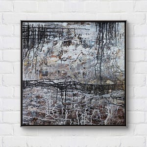 Può includere: Dipinto astratto con linee bianche e nere e gocce su uno sfondo grigio. Il dipinto ha una superficie testurizzata ed è incorniciato in una cornice nera.